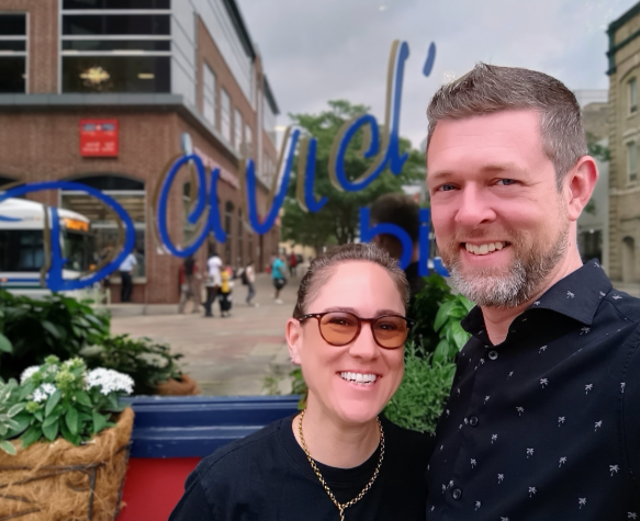Natalie and Ben outside David’s Bistro, the restaurant’s name painted on the window behind them