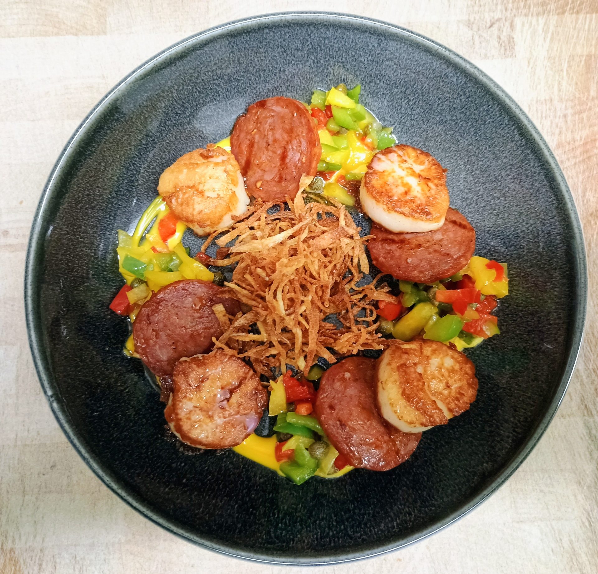 Seared scallops and chorizo over a bell pepper and caper relish with saffron aioli and crispy matchstick potatoes